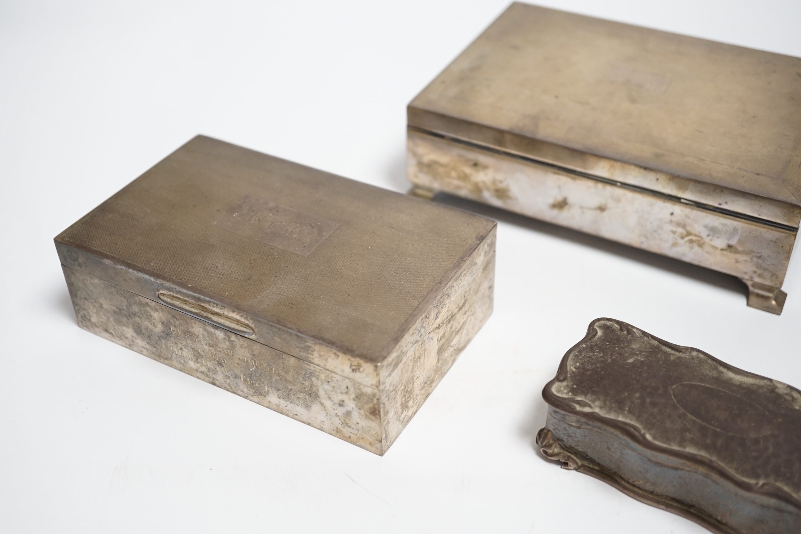 Two engine turned silver mounted cigarette boxes, the largest by Garrard & Co, London, 1955, 16.9cm and a silver trinket box.